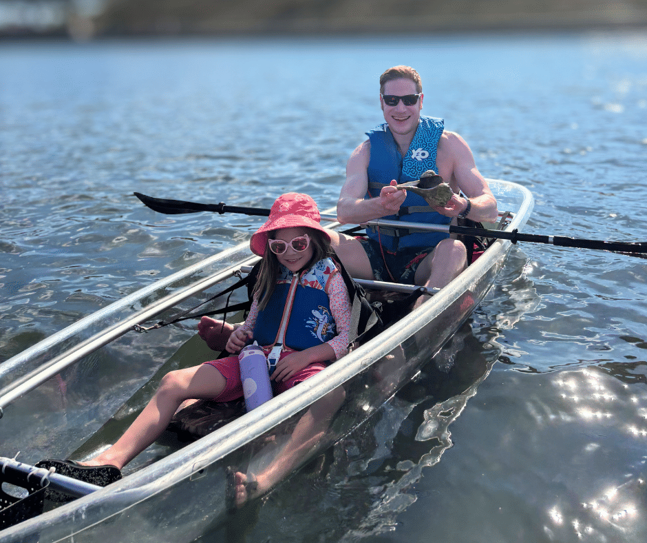 Family spotting manatee under kayak