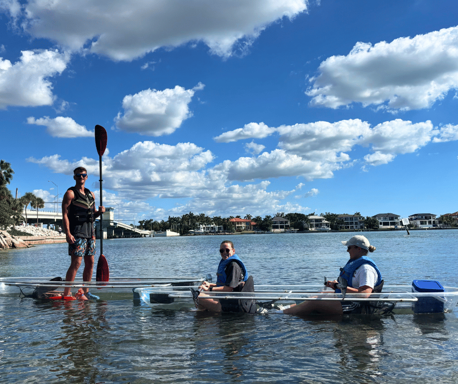 Family spotting manatee under clear kayak in Sarasota